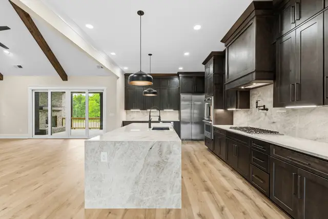 Charcoal cabinetry with a marble waterfall island