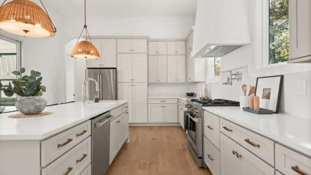 Oyster kitchen with a plaster hood and brass fixtures