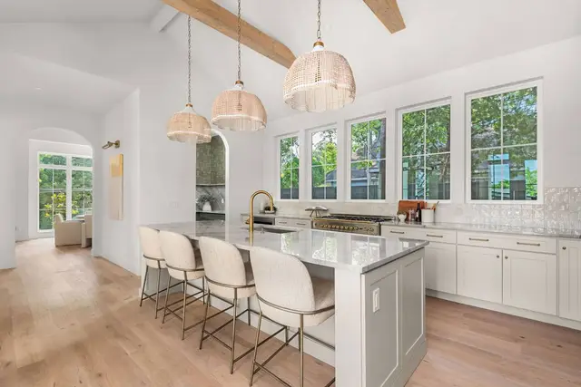 Oyster cabinetry under a vaulted beam ceiling