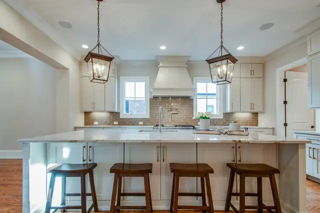 Oyster cabinetry with a painted hood and subway tile