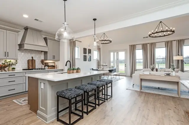 Pearl kitchen with a painted hood open to the living room