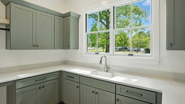 Pewter Green laundry cabinetry with a window sink run