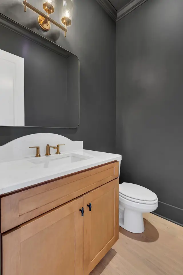 Sand powder room vanity against a dark wall