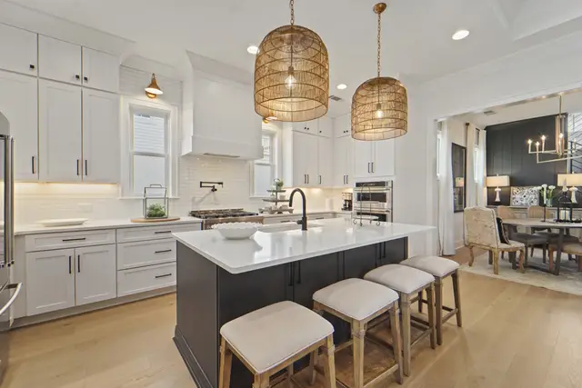 Timberland White kitchen with a Black island and woven pendants