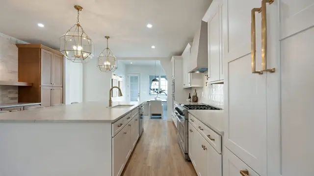 Timberland White kitchen with brass hardware and a marble island
