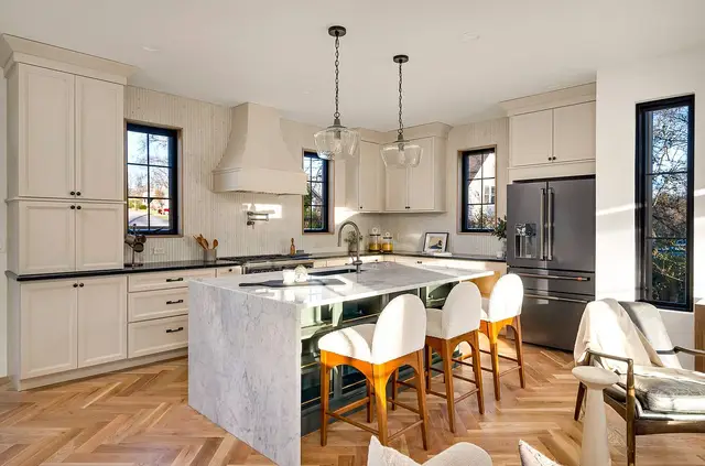 Marble island with counter seating in an Oyster full overlay kitchen