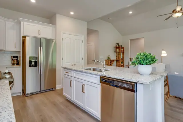 Timberland White raised-panel kitchen with a granite island